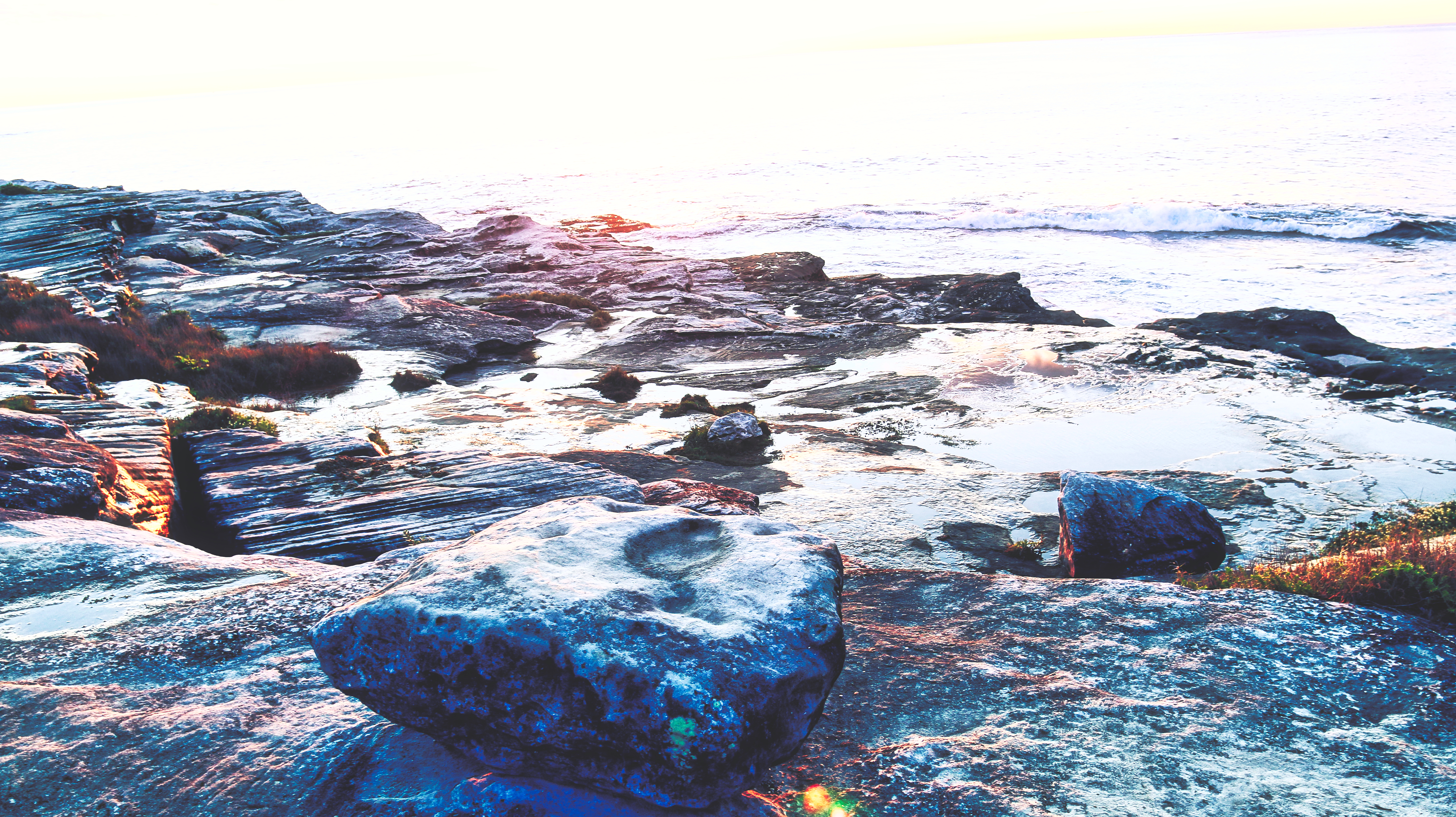 The morning sun shining on rocks along the coast